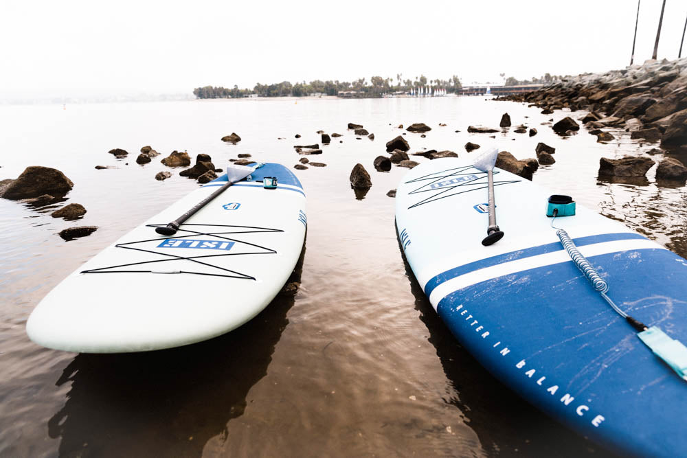 2 paddle boards on sand