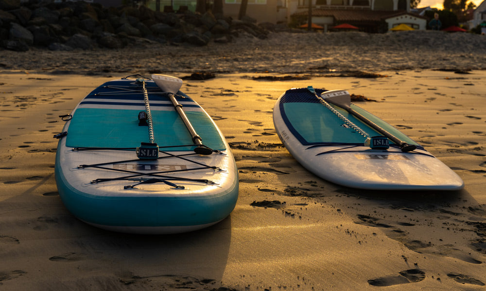 2 SUP  boards sitting on sand
